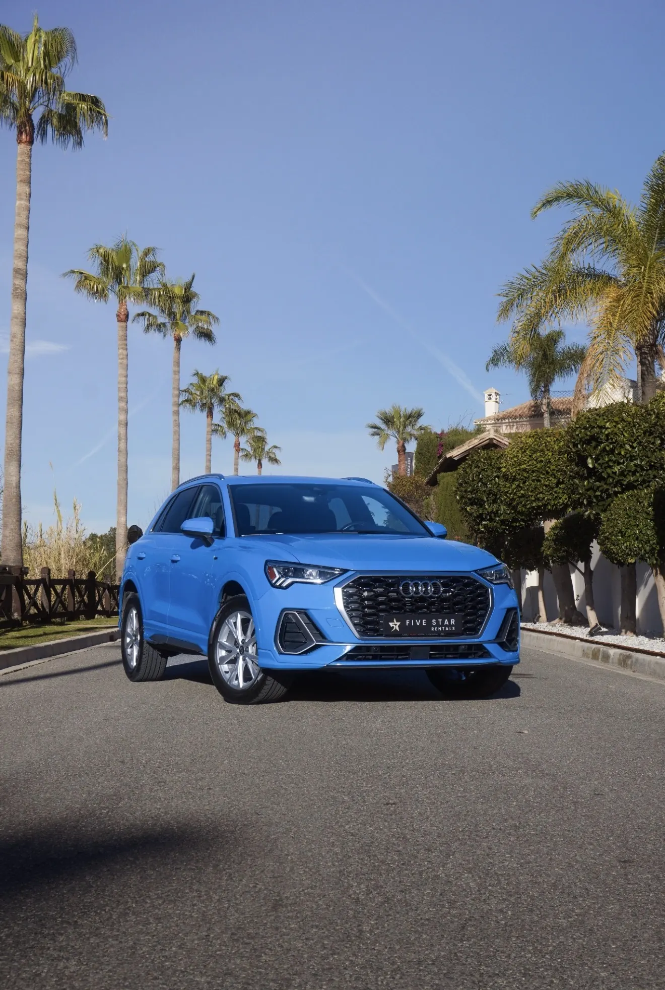 Audi Q3 45 TFSI Quattro S Line in Turbo Blue, front three-quarter view with Five Star Rentals plate, Singleframe grille and Marbella palm trees