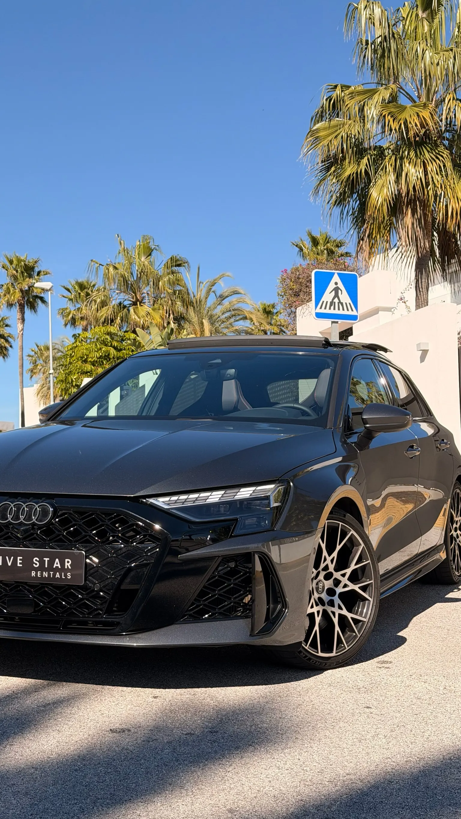 Audi RS3 Sportback close-up front three-quarter view with prominent RS air intakes under Marbella blue sky