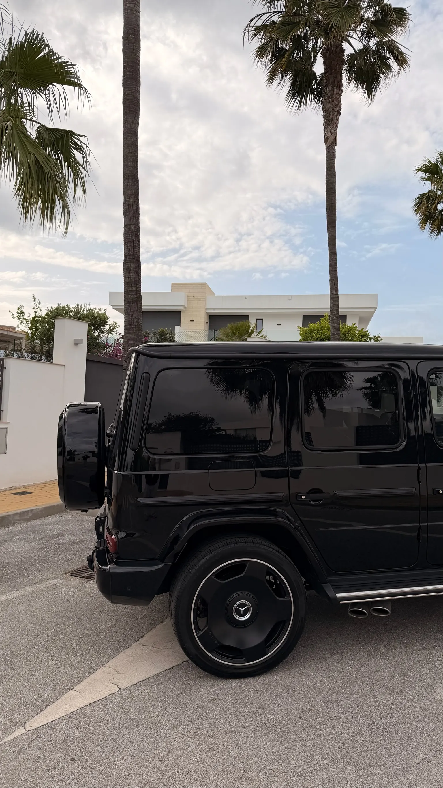 Detail of the 22-inch black AMG 5-spoke covered wheel with chrome lip and central Mercedes star logo on the G63