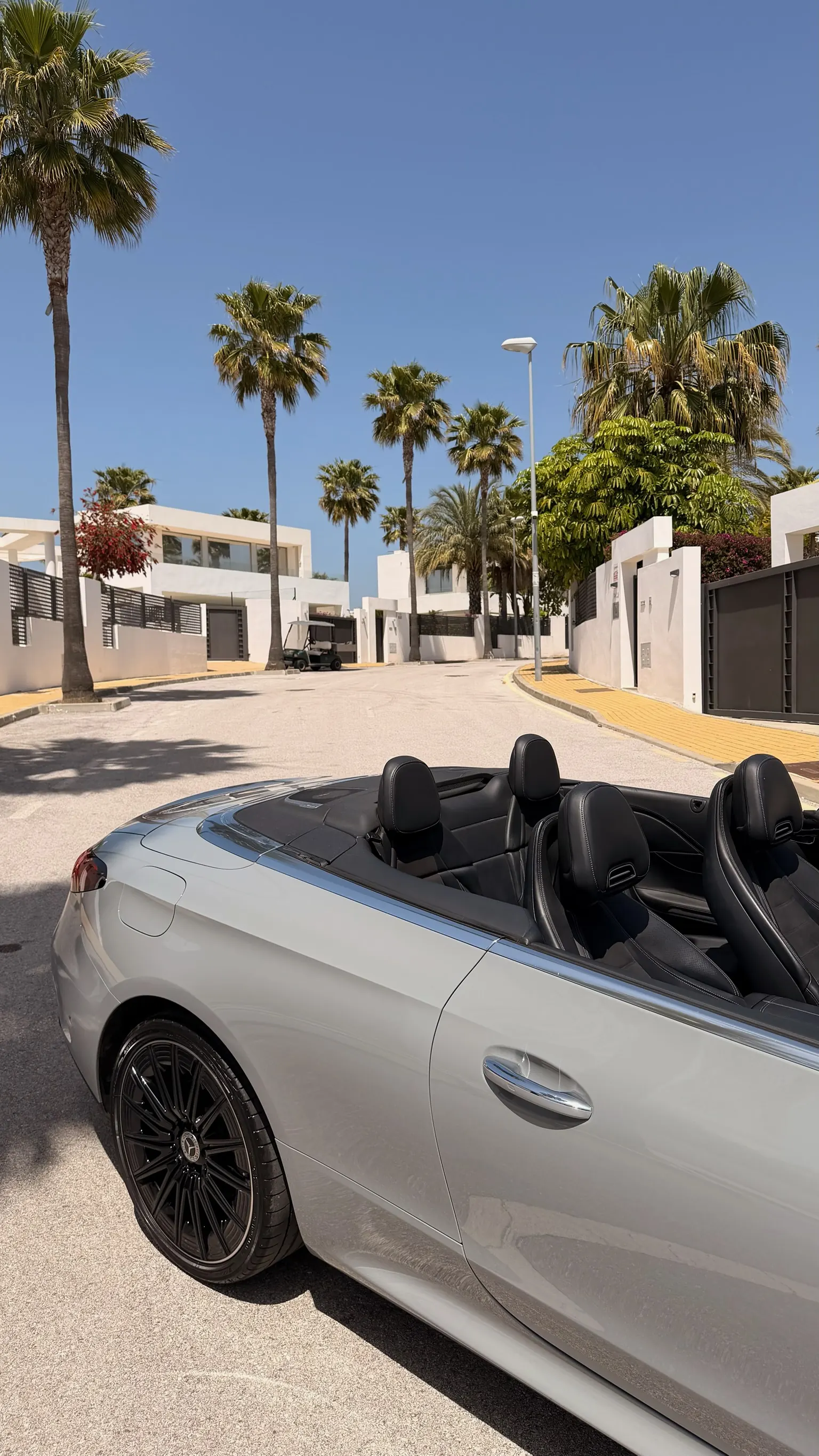 Top-down view of the 4-seater CLE 200 Cabriolet interior with top open, AMG black leather sport seats and rear headrests
