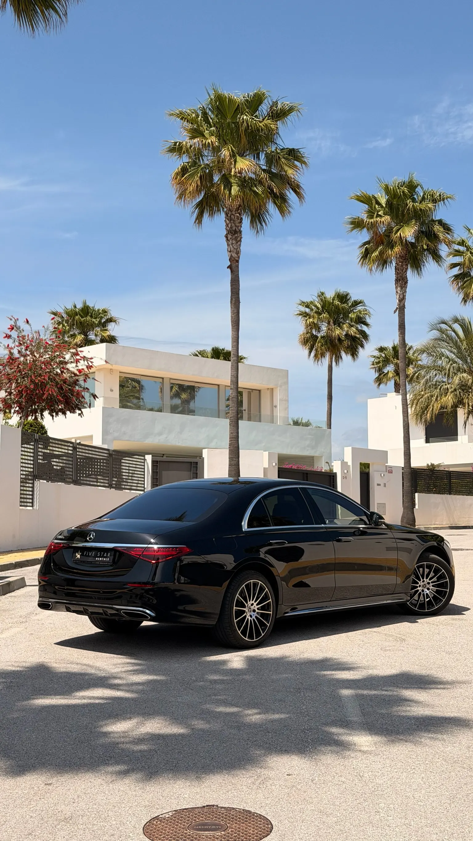 Rear three-quarter view of the Mercedes-Benz S 580 e with Five Star Rentals plate, integrated dual exhaust and panoramic glass roof