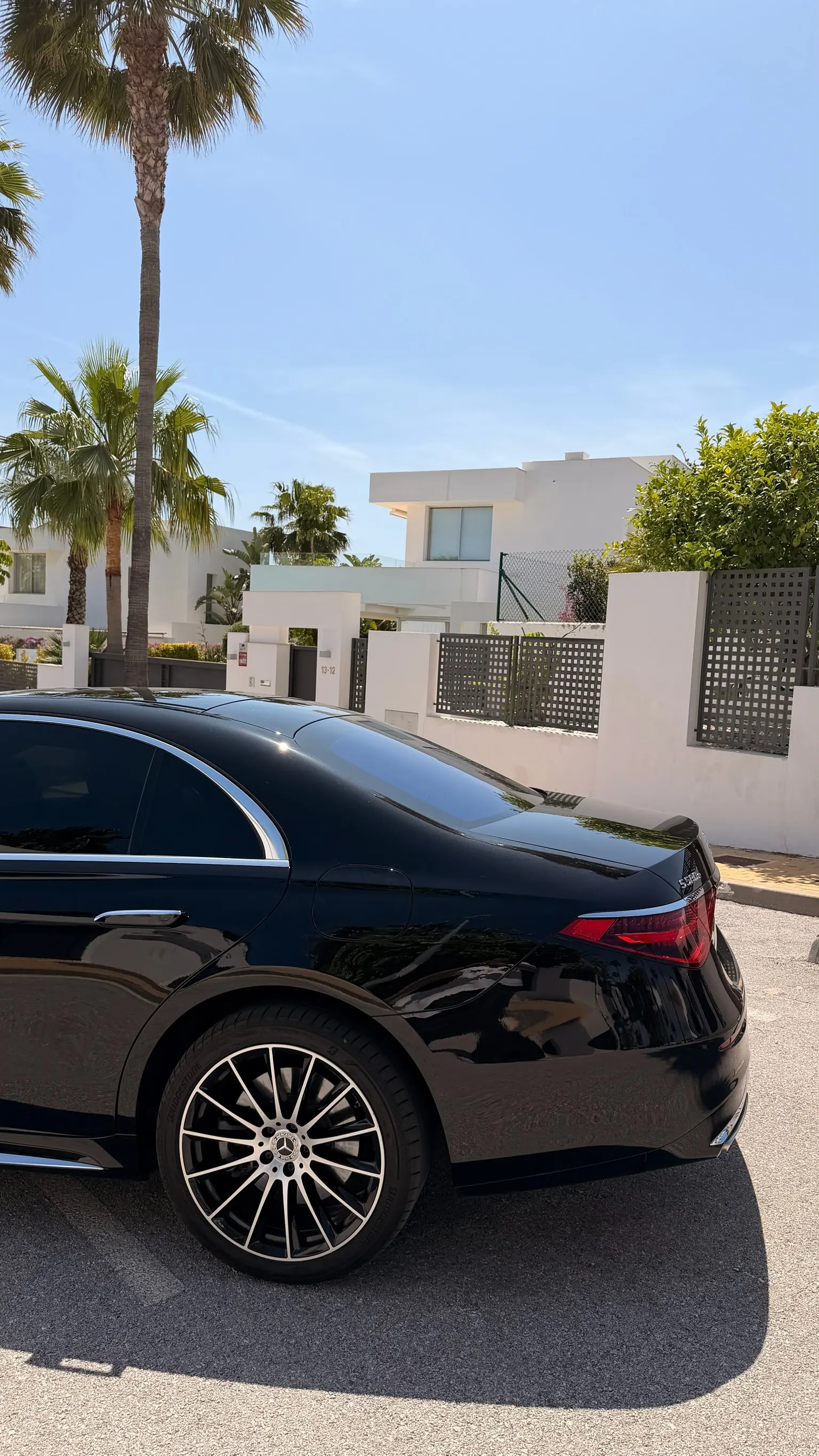 Rear side profile of the Obsidian Black Mercedes-Benz S 580 e with two-tone multi-spoke wheel, clean W223 lines and hidden charge port