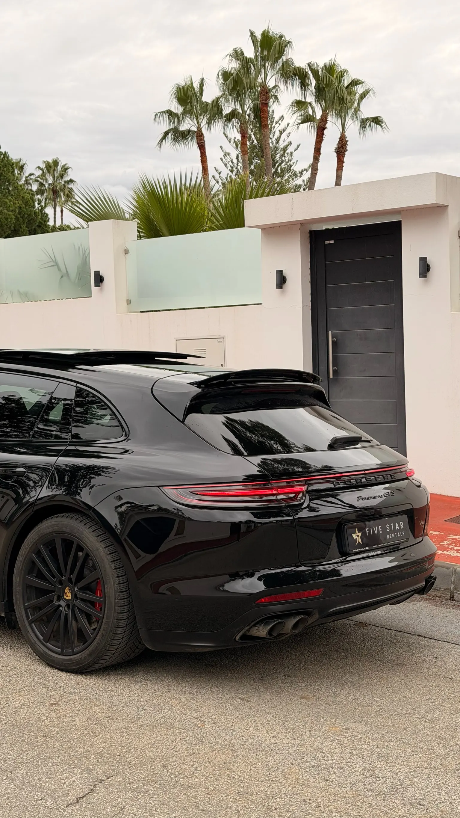 Porsche Panamera GTS rear detail with GTS badge, central sport exhaust and Five Star Rentals plate
