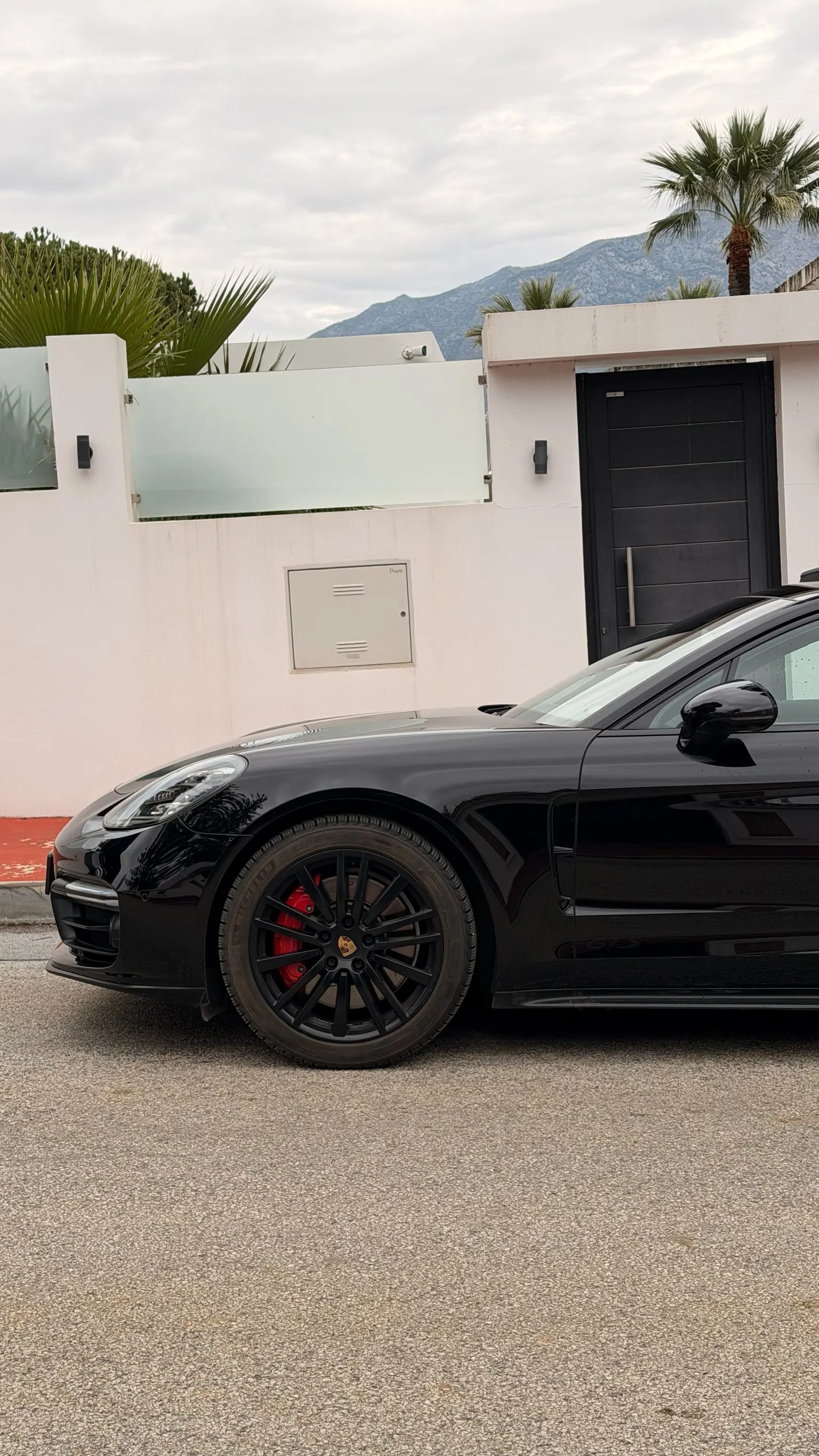 Side profile of the black Panamera GTS with 21-inch wheels and red brake calipers, La Concha mountain in background